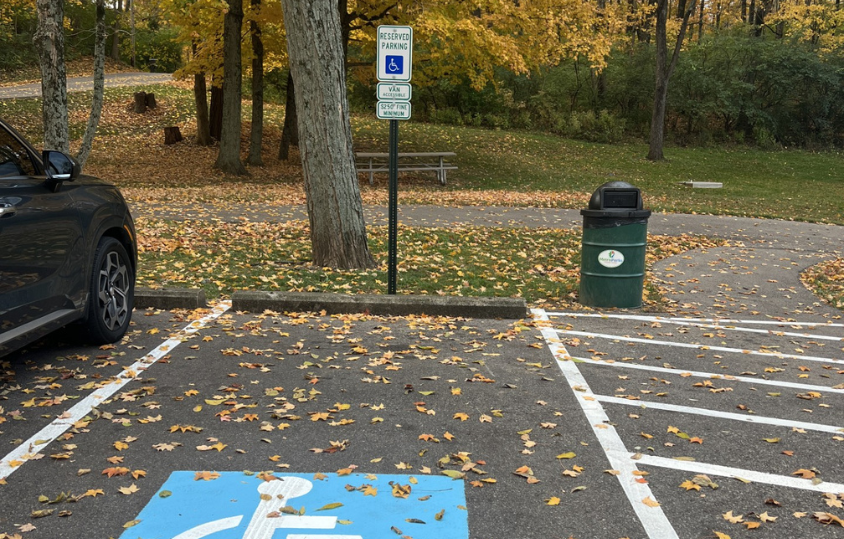 Apictureofahandicappedparkingspotinaparkwithfallingorangeleaves